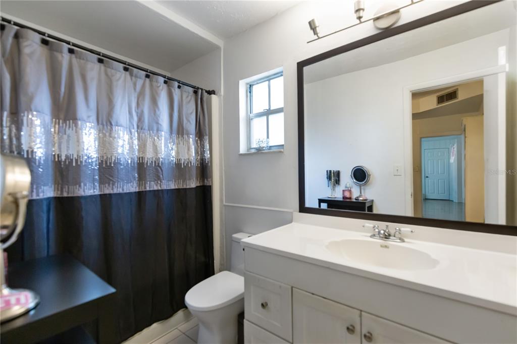 4303 Anderson Road Orlando, FL 32812 - Photo 16 of 47 a bathroom with a sink a toilet a mirror and shower