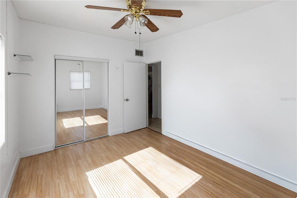 4303 Anderson Road Orlando, FL 32812 - Photo 32 of 47 an empty room with wooden floor mirror and windows