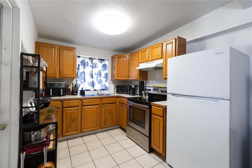 4303 Anderson Road Orlando, FL 32812 - Photo 4 of 47 a kitchen with stainless steel appliances granite countertop a refrigerator sink and cabinets