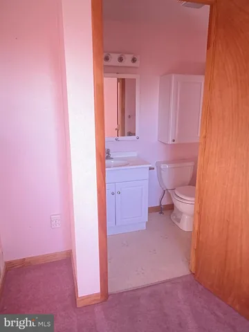 a view of a kitchen with white cabinets and wooden floor