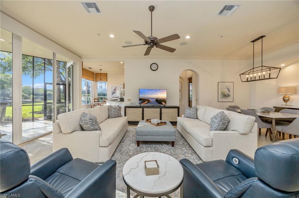15532 Monterosso Lane, Unit 102 Naples, FL 34110 - Photo 11 of 49 a living room with furniture a rug and a chandelier