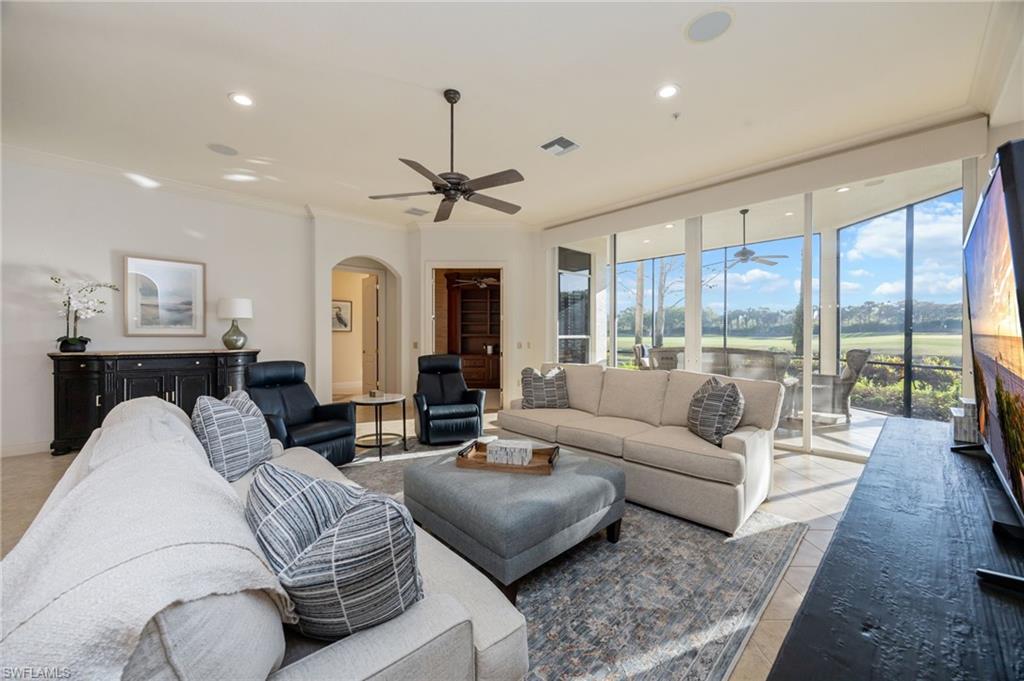 15532 Monterosso Lane, Unit 102 Naples, FL 34110 - Photo 12 of 49 a living room with furniture ceiling fan and a large window