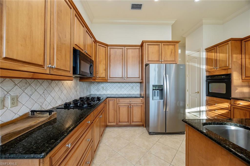 15532 Monterosso Lane, Unit 102 Naples, FL 34110 - Photo 19 of 49 a kitchen with granite countertop stainless steel appliances a refrigerator a stove top oven and granite counter tops