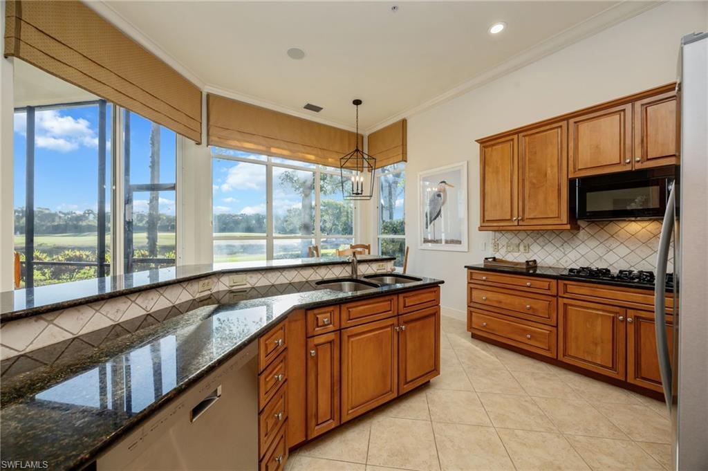 15532 Monterosso Lane, Unit 102 Naples, FL 34110 - Photo 20 of 49 a large kitchen with granite countertop a sink and cabinets
