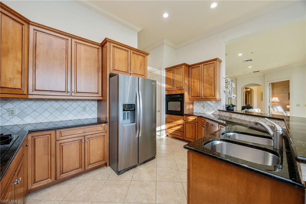15532 Monterosso Lane, Unit 102 Naples, FL 34110 - Photo 21 of 49 a kitchen with stainless steel appliances granite countertop a refrigerator and a stove top oven