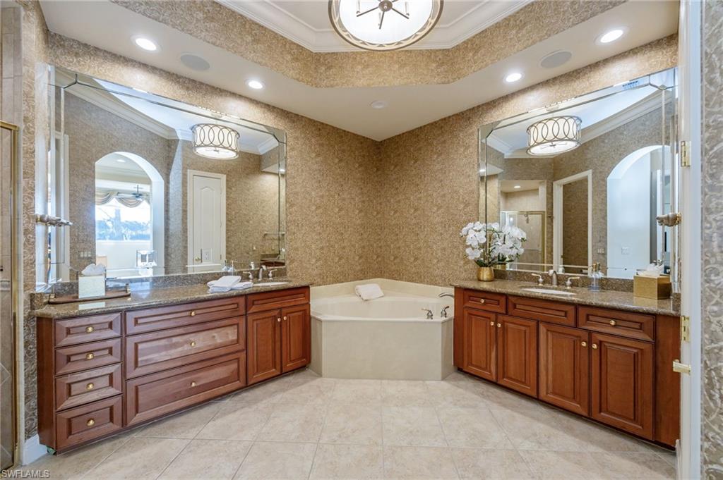 15532 Monterosso Lane, Unit 102 Naples, FL 34110 - Photo 25 of 49 a spacious bathroom with a granite countertop double vanity sink mirror and bathtub