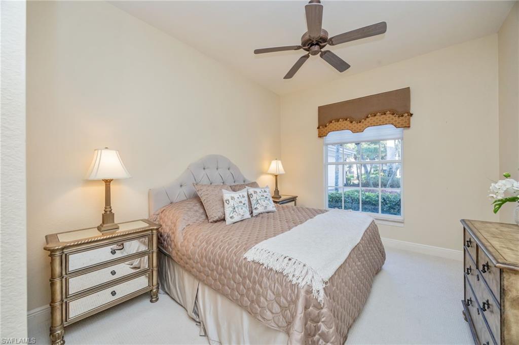 15532 Monterosso Lane, Unit 102 Naples, FL 34110 - Photo 27 of 49 a bedroom with a bed chandelier and a window
