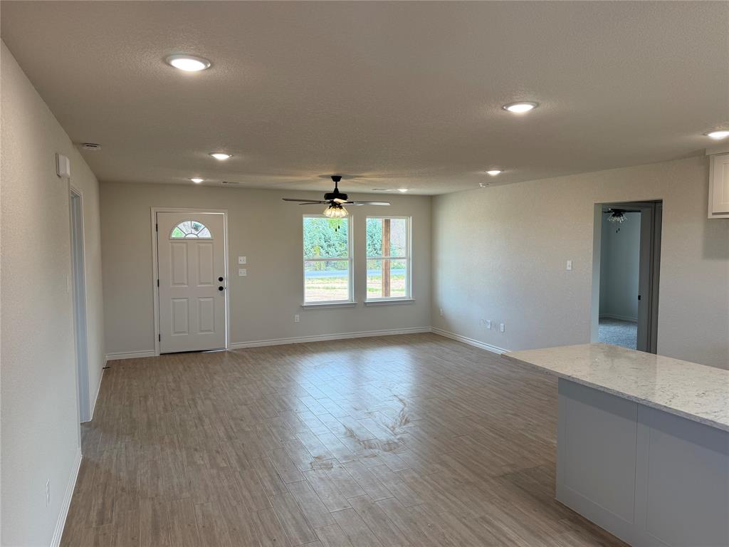 2998 Knob Road Springtown, TX 76082 - Photo 3 of 7 an empty room with wooden floor and windows