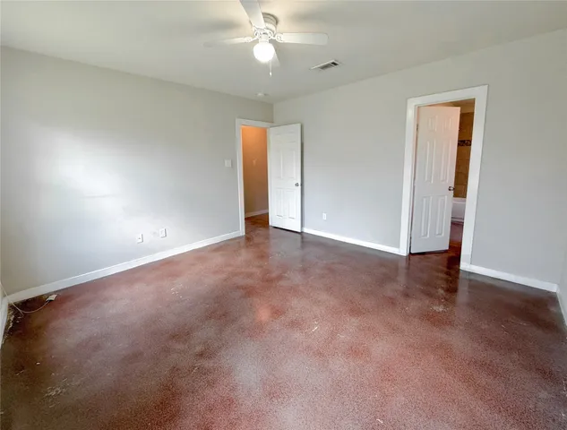 an empty room with a ceiling fan and a window