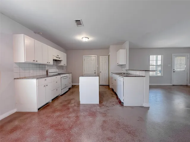 a large kitchen with cabinets and stainless steel appliances