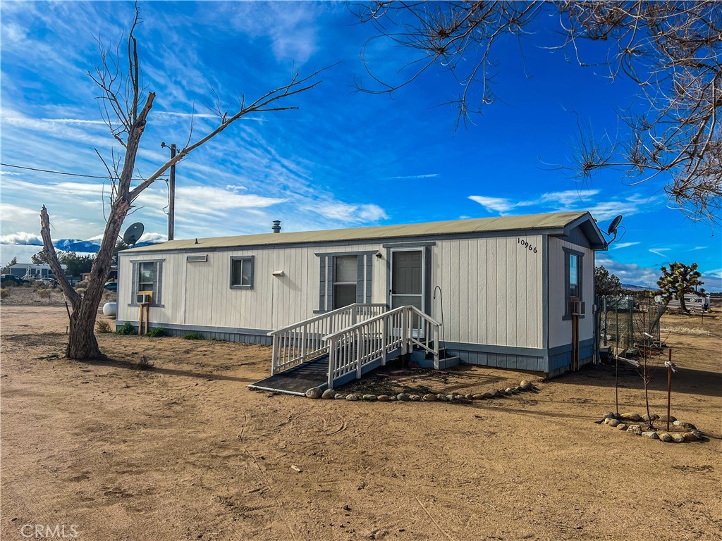 10966 Wilson Ranch Road Phelan, CA 92371 - Photo 1 of 1 a view of a house with backyard and sitting area