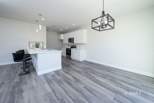 327 Abigail Street Ridgecrest, CA 93555 - Photo 12 of 35 a view of a kitchen with a sink and dishwasher a refrigerator with wooden floor