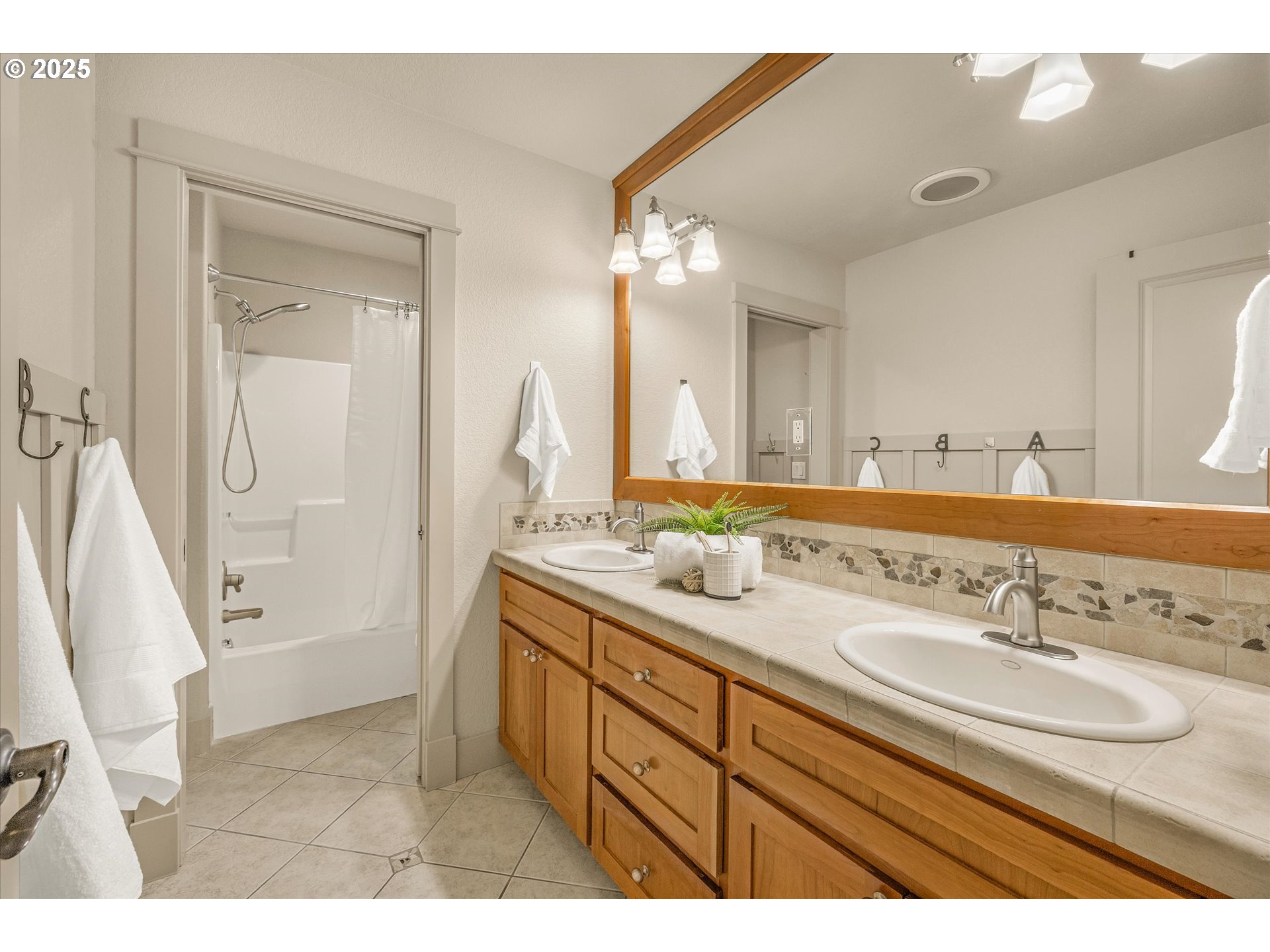 14697 Southeast Poppy Hills Drive Happy Valley, OR 97086 - Photo 27 of 48 a bathroom with a sink double vanity granite tub shower and a mirror