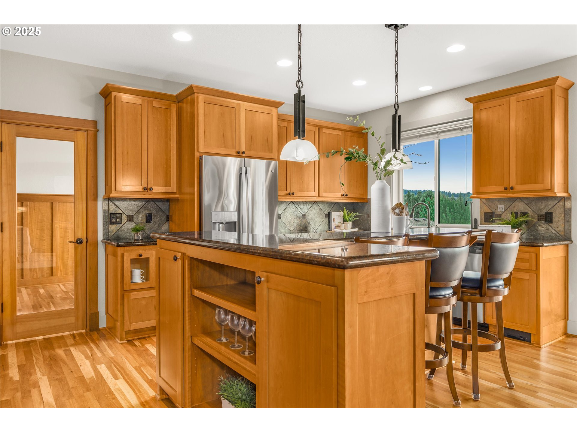 14697 Southeast Poppy Hills Drive Happy Valley, OR 97086 - Photo 7 of 48 a kitchen with stainless steel appliances kitchen island granite countertop a refrigerator a stove a sink dishwasher and a dining table with wooden cabinet