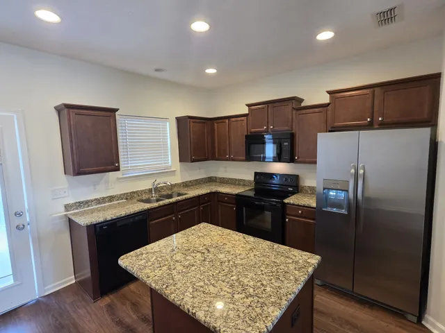 a kitchen with a refrigerator sink and wooden cabinets