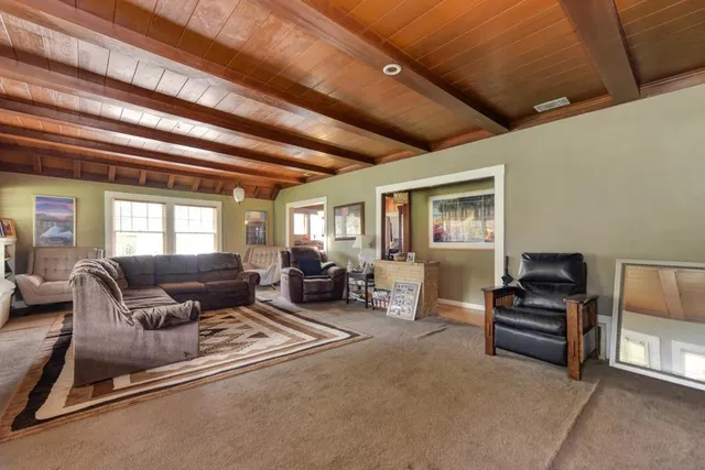 a bedroom with a bed and dresser with wooden floor