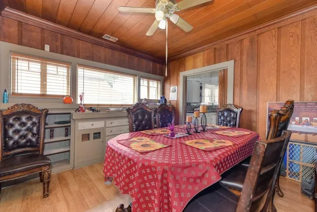 a kitchen with stainless steel appliances granite countertop a refrigerator a stove a sink dishwasher and a dining table with wooden floor