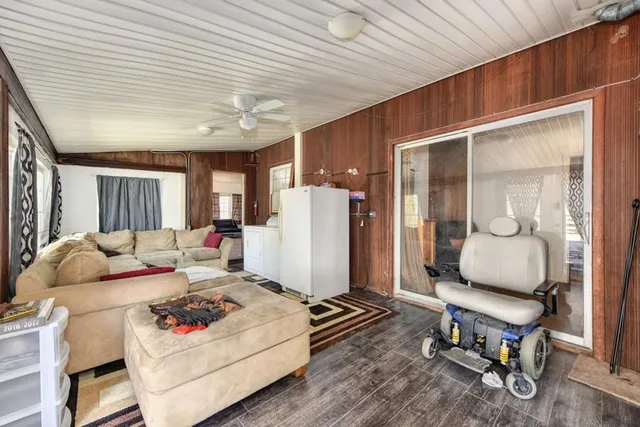 a view of a patio with table and chairs potted plants with wooden floor and fence