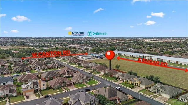 an aerial view of residential houses with outdoor space and trees