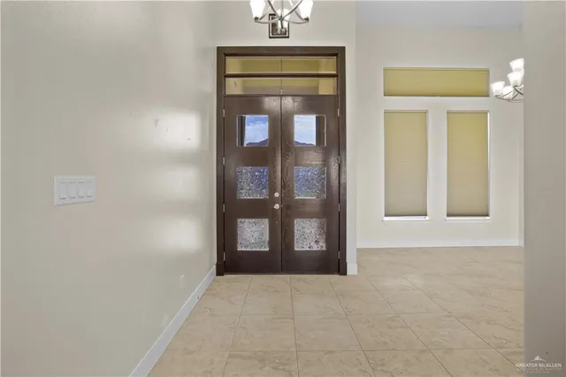 a view of a livingroom with a chandelier fan and windows