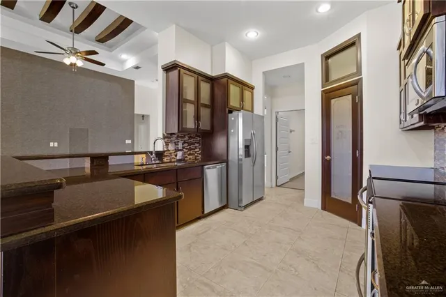 an empty room with a chandelier fan and windows