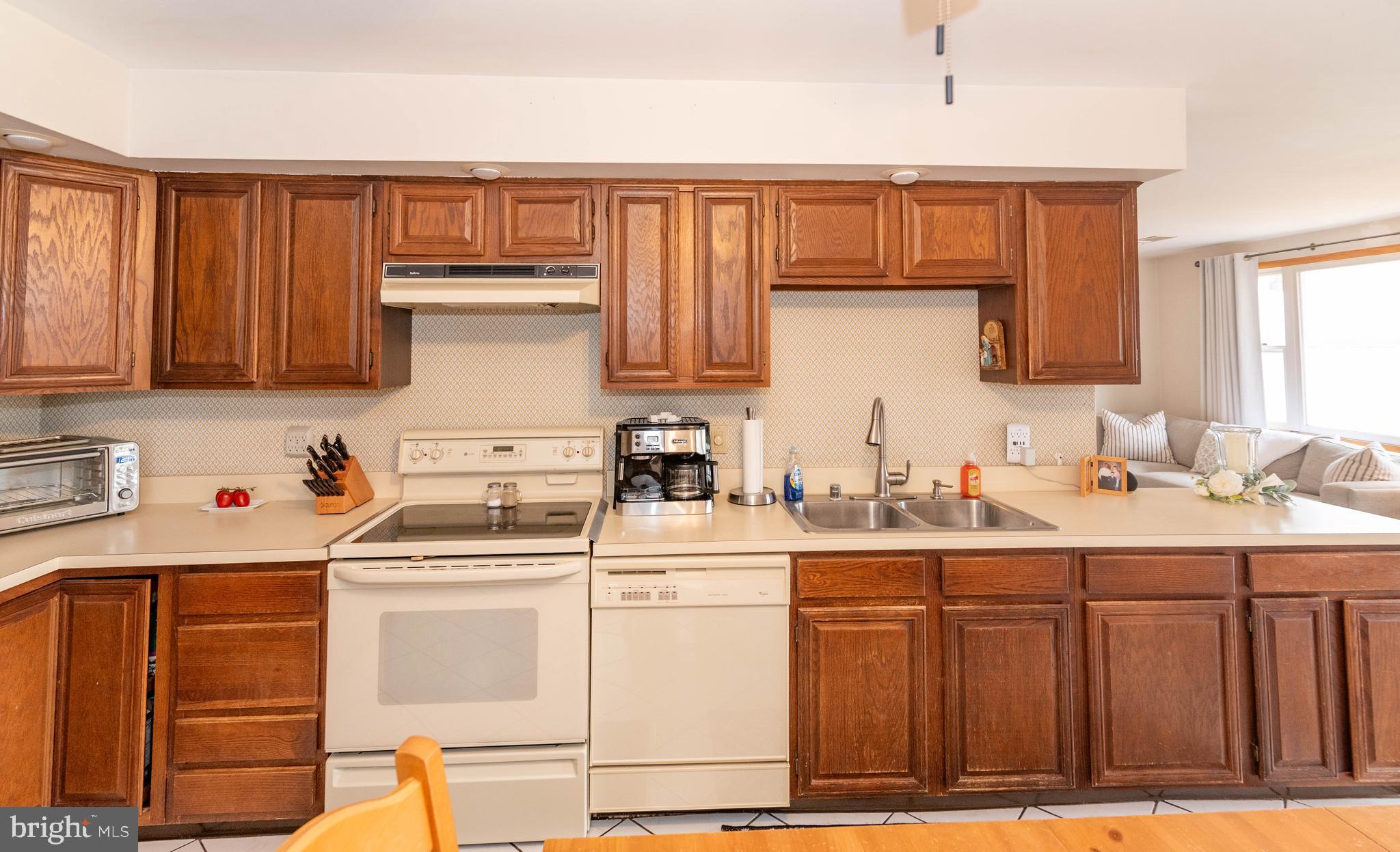 7316 Greenbank Road Baltimore, MD 21220 - Photo 18 of 87 a kitchen with a sink a stove cabinets and a wooden floor