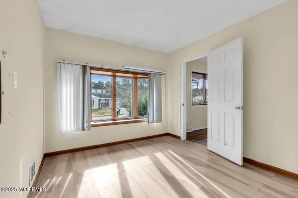 a view of a big room with wooden floor and windows in a room
