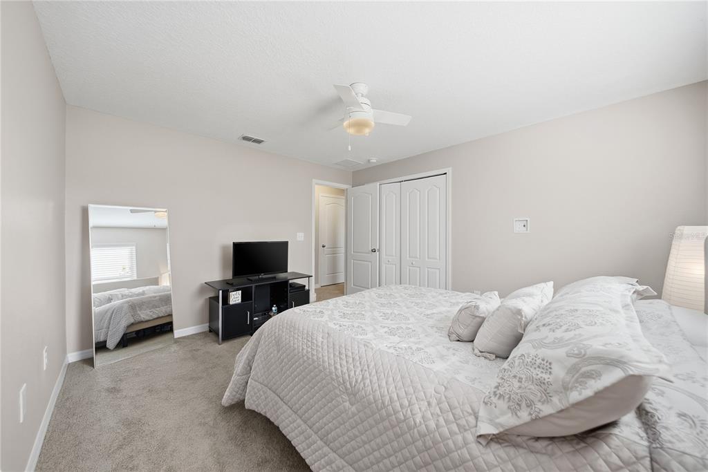8605 Fiddleleaf Court Tampa, FL 33647 - Photo 19 of 26 a bedroom with a bed and a chandelier