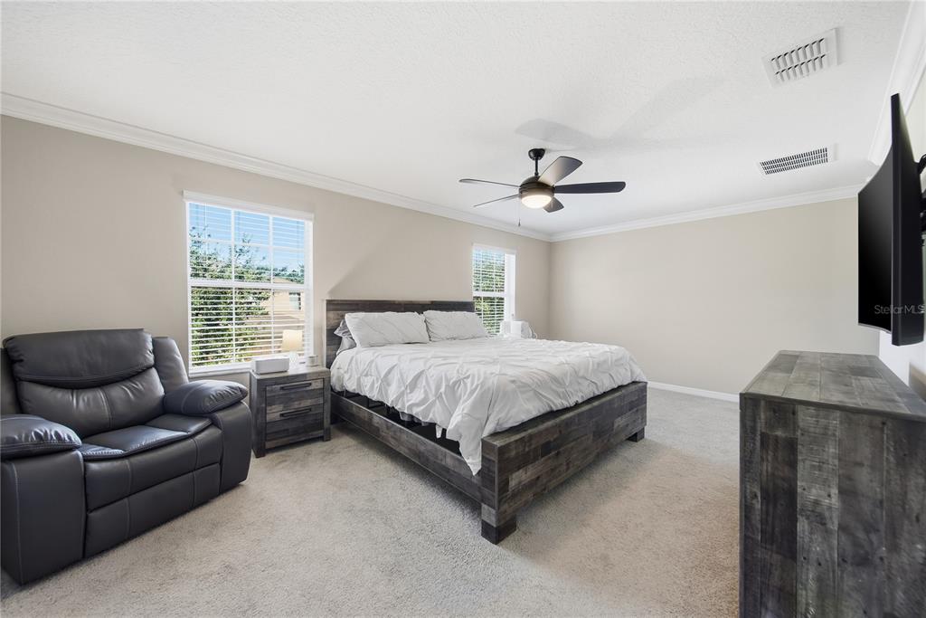 8605 Fiddleleaf Court Tampa, FL 33647 - Photo 24 of 26 a spacious bedroom with a bed and a couch