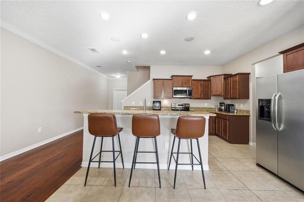 8605 Fiddleleaf Court Tampa, FL 33647 - Photo 4 of 26 a kitchen with stainless steel appliances kitchen island granite countertop a refrigerator and a stove top oven