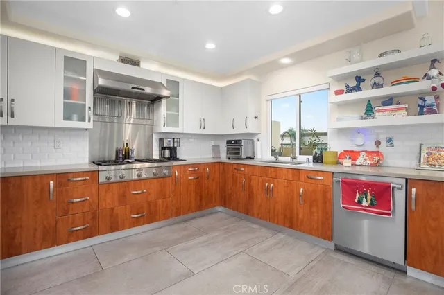 a kitchen with granite countertop lots of clutter and stainless steel appliances
