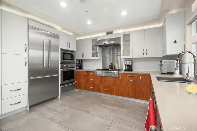 a kitchen with granite countertop a refrigerator and a sink