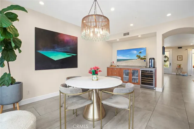 a view of a dining room with furniture a kitchen and chandelier