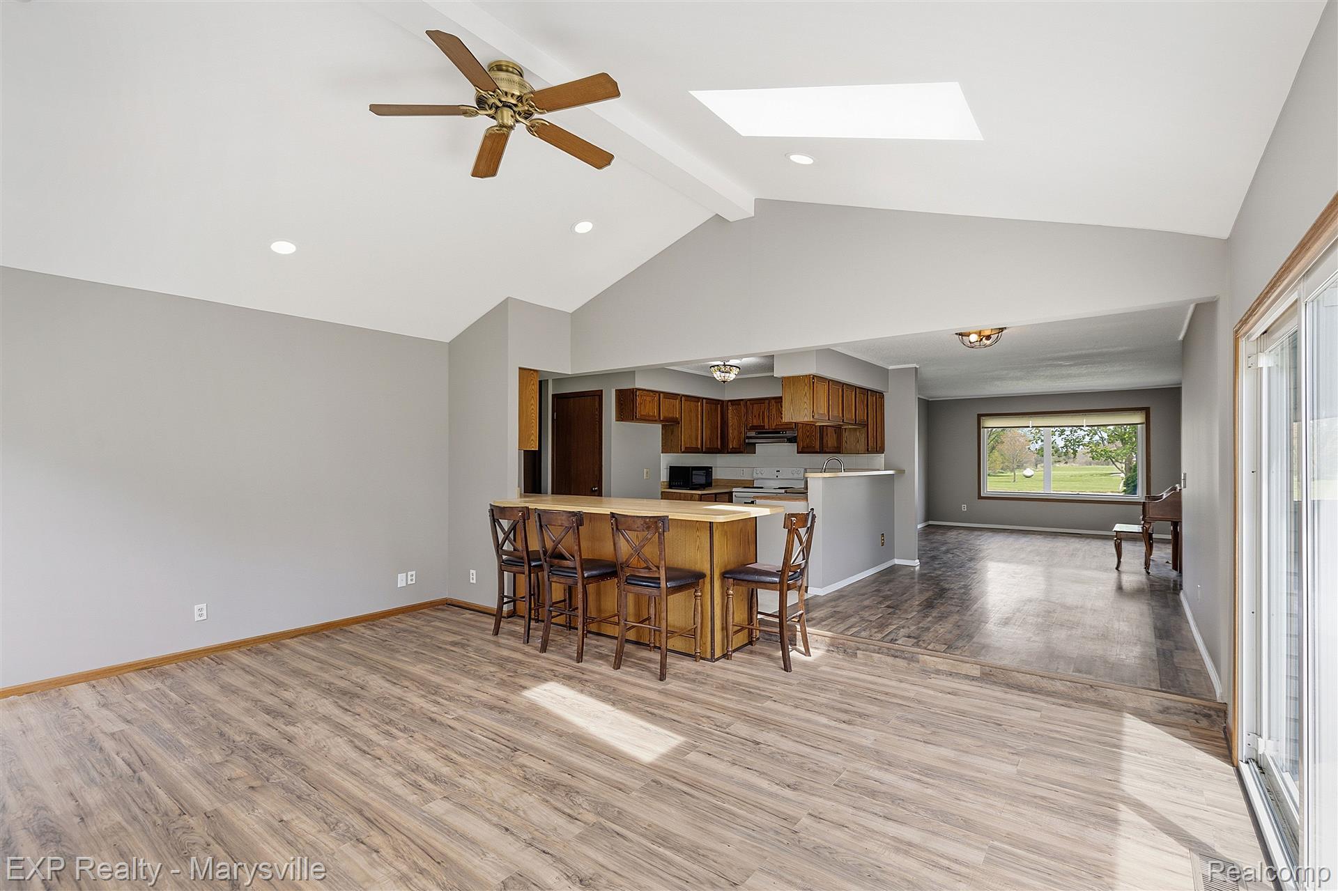 12265 Hough Road Memphis, MI 48041 - Photo 16 of 41 Kitchen with ceiling fan, a skylight, light wood finished floors, a peninsula, and a kitchen breakfast bar