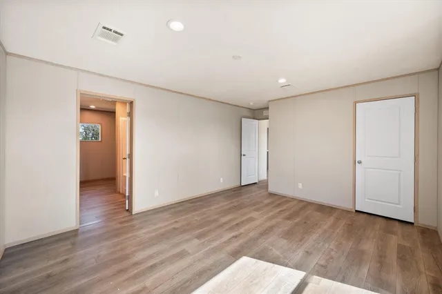 an empty room with wooden floor and closet