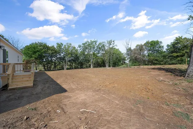 a backyard of a house with barbeque oven table and chairs