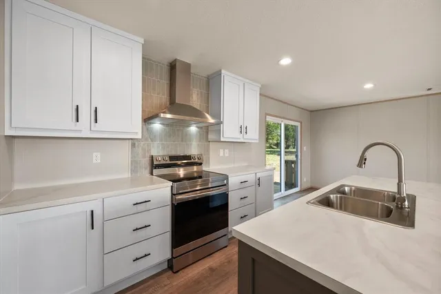 a kitchen with stainless steel appliances granite countertop a sink a stove and a refrigerator
