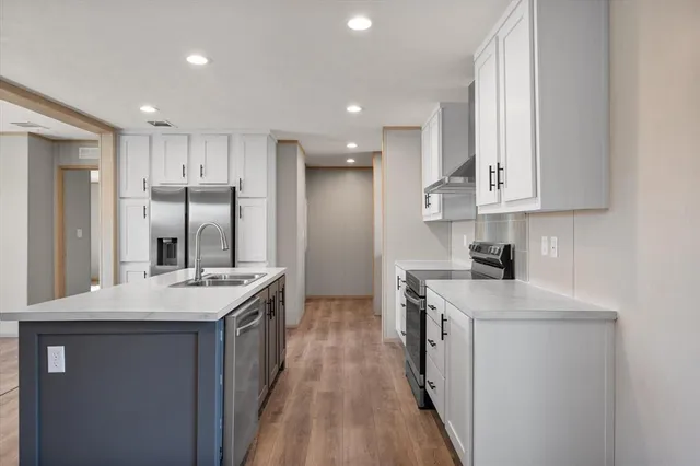 a kitchen with stainless steel appliances granite countertop a sink stove and refrigerator