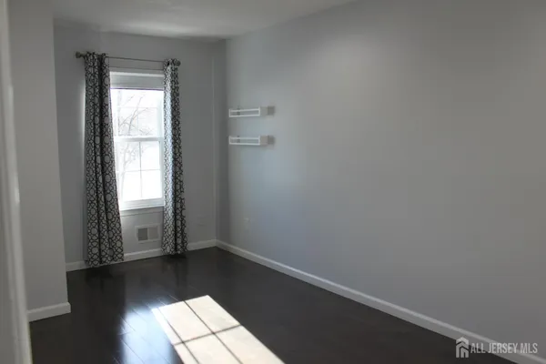 an empty room with wooden floor and closet