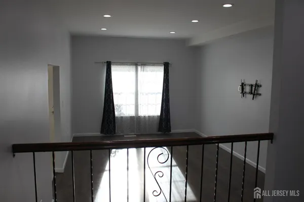 a view of staircase with lots of frames on wall and wooden floor