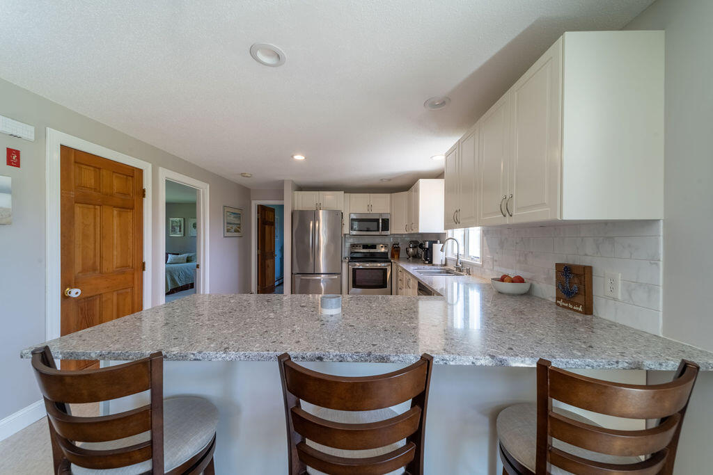 18 Windsor Road Sandwich, MA 02563 - Photo 8 of 35 a kitchen with stainless steel appliances granite countertop a table and chairs