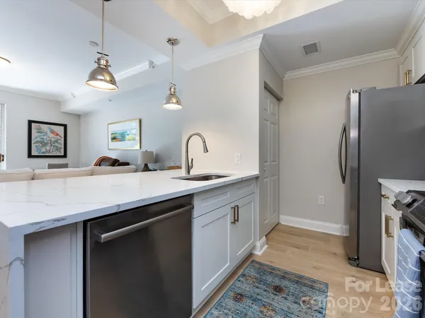 a kitchen with stainless steel appliances a sink a counter space and refrigerator