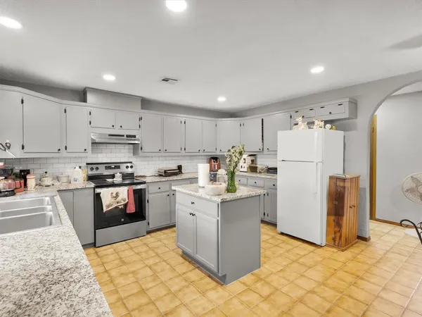 a kitchen with refrigerator and cabinets