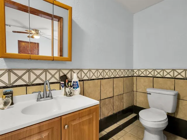 a bathroom with a sink mirror vanity and toilet