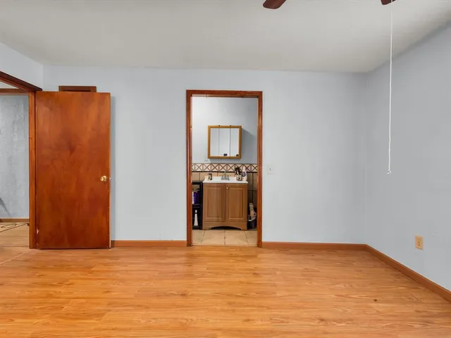 a view of a livingroom with wooden floor and a ceiling fan