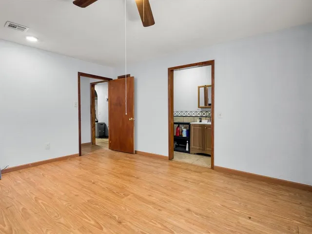 a view of an empty room with wooden floor and exposed radiator
