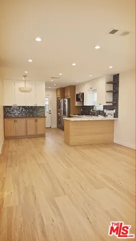 a kitchen with stainless steel appliances a refrigerator and a stove top oven