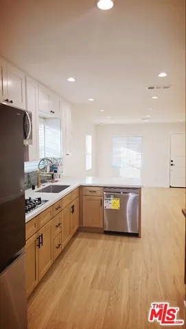 a large kitchen with stainless steel appliances granite countertop a stove a sink and a refrigerator