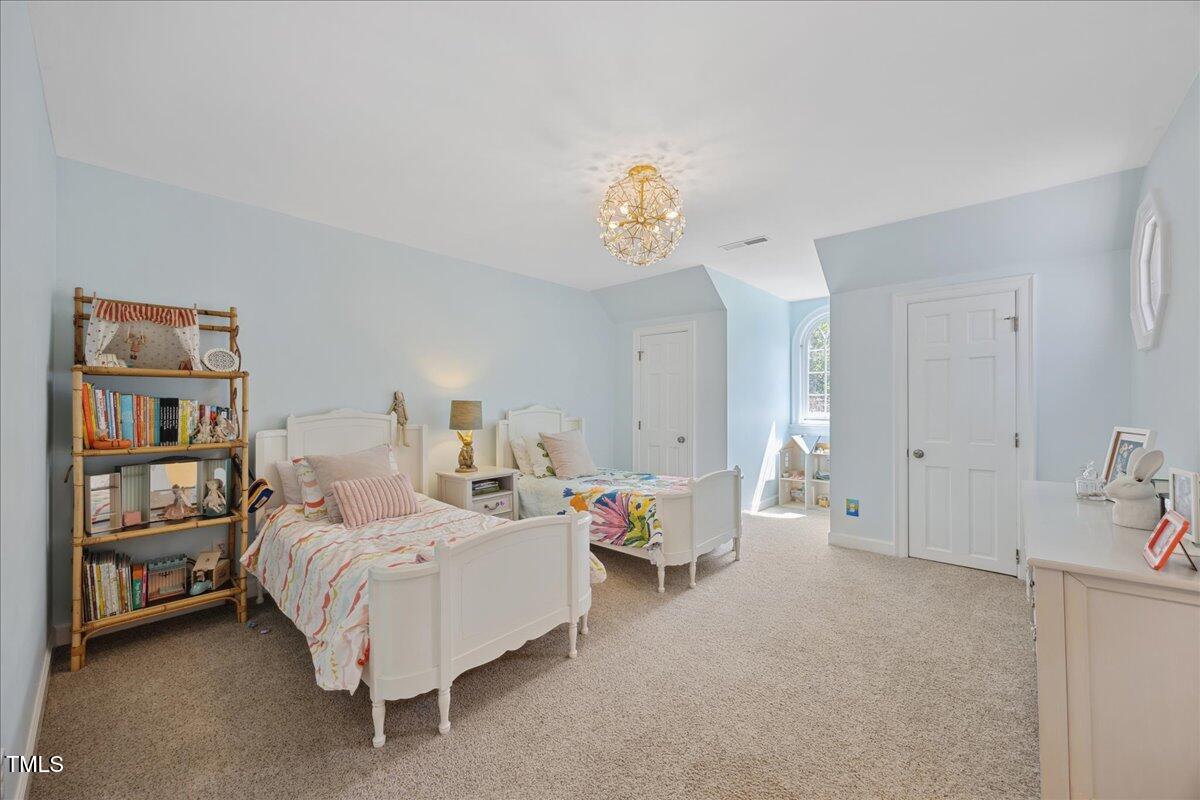 7917 Rooksley Court Raleigh, NC 27615 - Photo 28 of 45 a bedroom with a bed and a book shelf