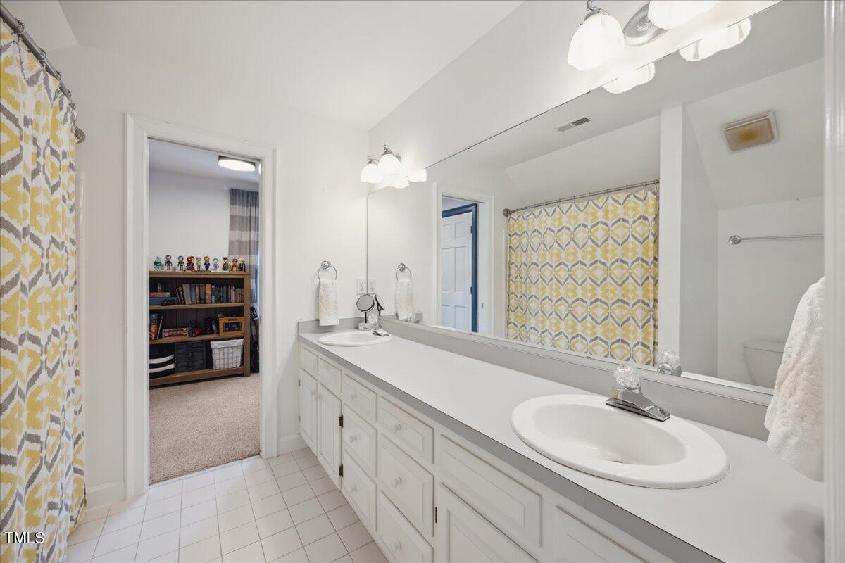 7917 Rooksley Court Raleigh, NC 27615 - Photo 30 of 45 a bathroom with a double vanity sink mirror and bathtub